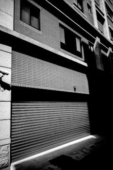 Monochrome image of a roller shutter on a building facade in Taiwan cityscape.