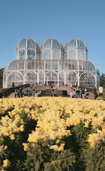 Stunning view of the botanical garden in Curitiba featuring its iconic greenhouse amidst vibrant flowers.